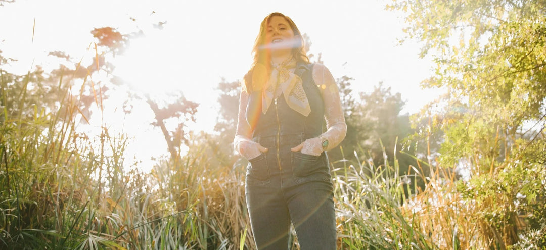 Alexa Wildish standing in tall grass in golden afternoon light